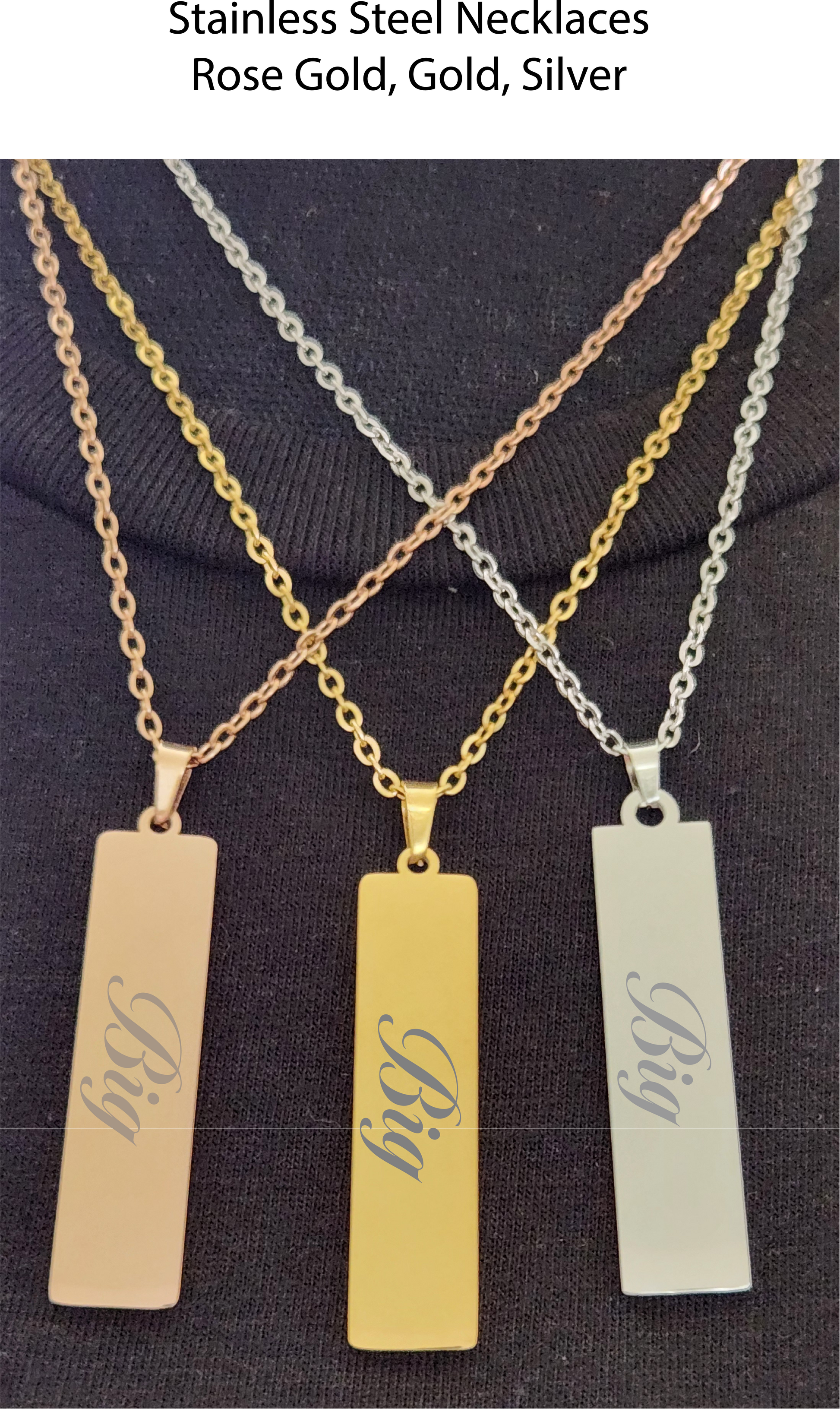Three necklaces with rectangular pendants engraved with 'Big' on a dark background