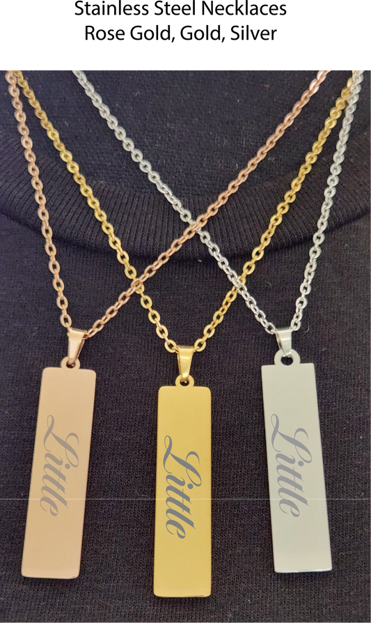 Three necklaces with 'Little' pendants on a dark background
