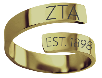 A polished gold-colored open band ring engraved with the Greek letters 'ΑΣΑ' on the top segment and 'EST. 1907' on the lower segment, isolated on a white background.