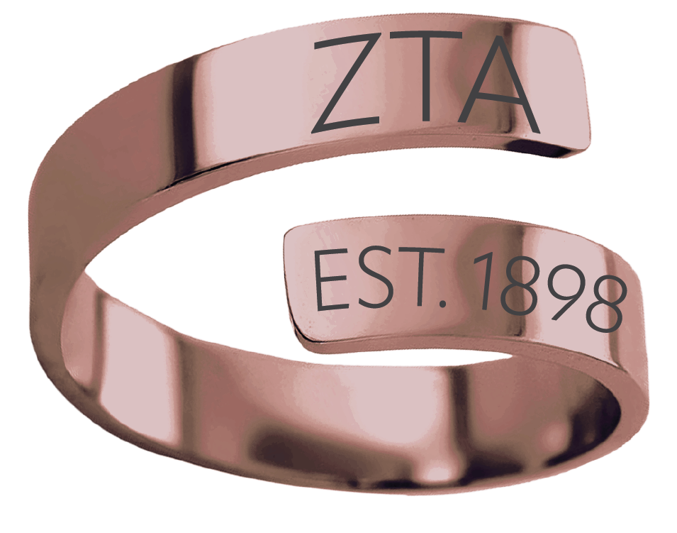 A rose gold open band ring engraved with 'ZTA' and 'EST. 1898' in black lettering, shown on a solid white background.
